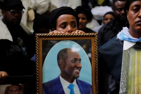 A mourner holds the photo of Amhara president Mekonnen during a funeral ceremony in the town of Bahir Dar