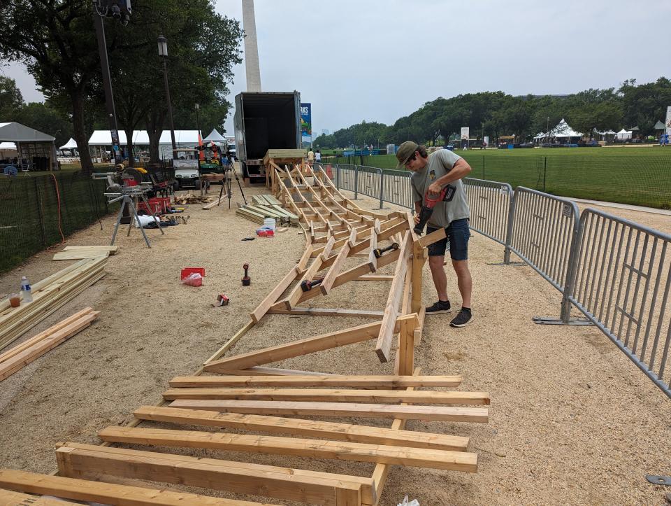 Seth Gebel, owner of Backyard Trail Builds, constructs a 100-foot wooden mountain bike feature on the National Mall for the annual Smithsonian Folklife Festival.