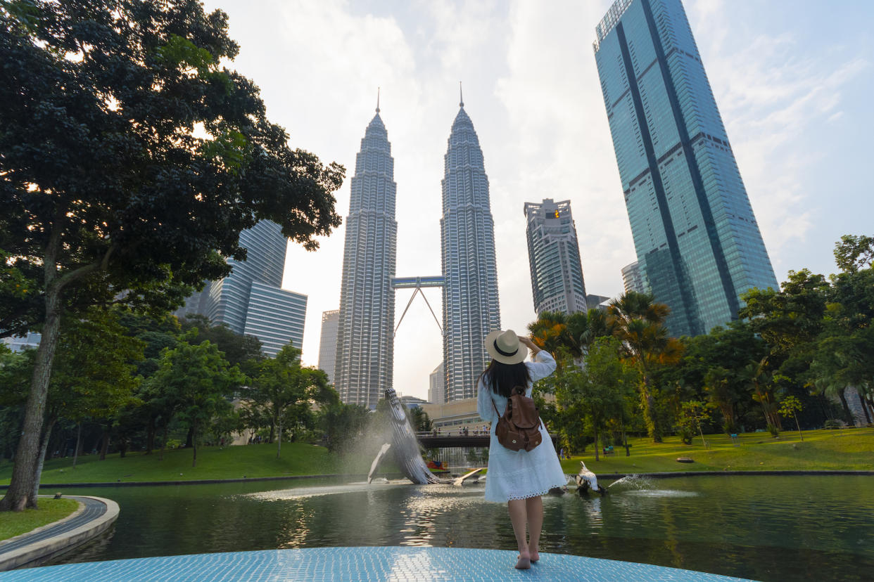 A tourist in front of the Kuala Lumpur Convention Centre Twin Towers