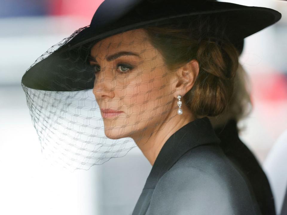 Kate Middleton looks out of the window of a car as she trails behind Queen Elizabeth's casket.