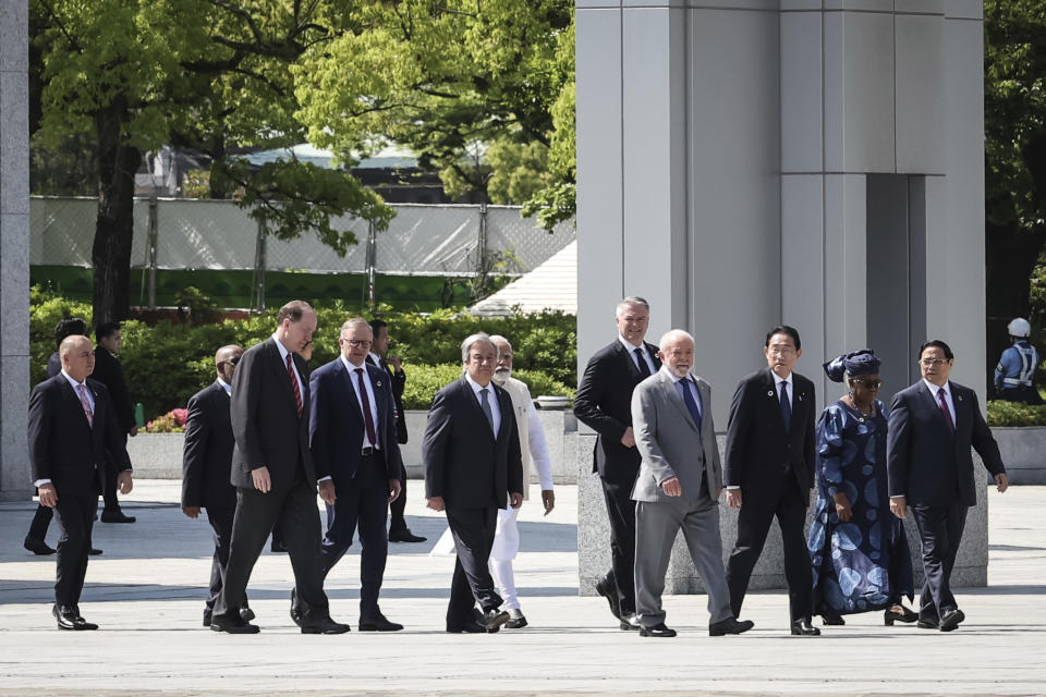 From left, Cook Islands' Prime Minister Mark Brown, Comoros' President Azali Assoumani, World Bank President David Malpass, Australia's Prime Minister Anthony Albanese, United Nations Secretary General Antonio Guterres, India's Prime Minister Narendra Modi, Organization for Economic Co-operation and Development (OECD) Secretary-General Mathias Cormann, Brazil's President Luiz Inacio Lula da Silva, Japan's Prime Minister Fumio Kishida, World Trade Organization (WTO) Director-General Ngozi Okonjo-Iweala, and Vietnam's Prime Minister Pham Minh Chinh walk from the Peace Memorial Museum to a wreath-laying ceremony in the Peace Memorial Park in Hiroshima, western Japan Sunday, May 21, 2023, on the sidelines of the G7 summit. (Takashi Aoyama/Pool Photo via AP)