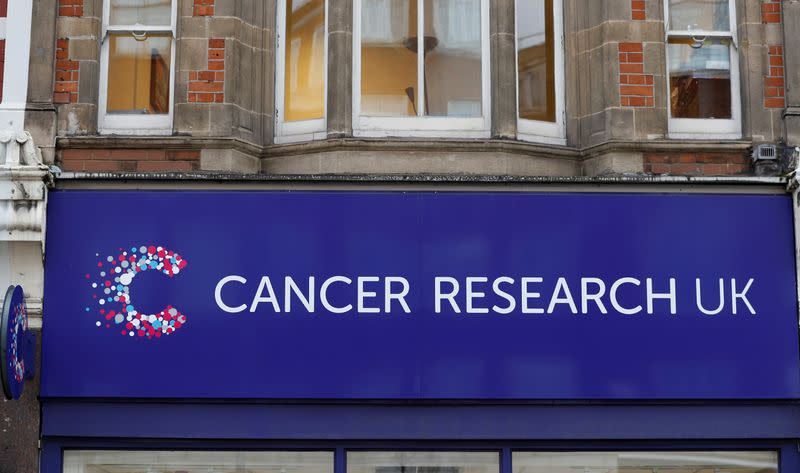 A sign above a Cancer Research UK store is seen in London