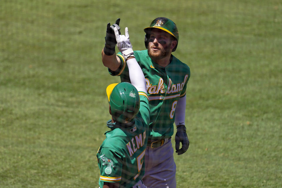 Oakland Athletics' Robbie Grossman, right, celebrates with Tony Kemp after hitting a two-run home run during the second inning of a baseball game against the Los Angeles Angels Wednesday, Aug. 12, 2020, in Anaheim, Calif. (AP Photo/Mark J. Terrill)