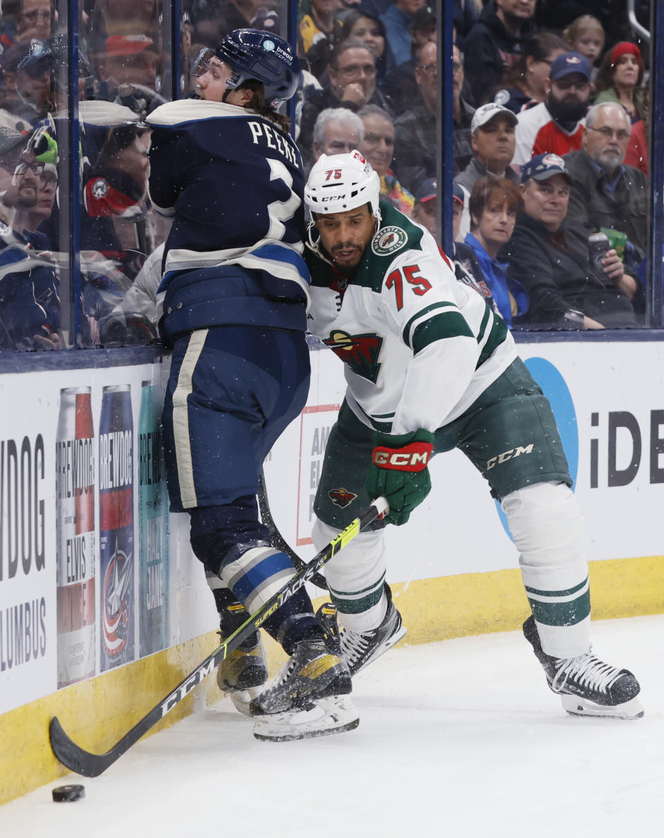 Minnesota Wild's Ryan Reaves, right, steals the puck from Columbus Blue Jackets' Andrew Peeke during the first period of an NHL hockey game Thursday, Feb. 23, 2023, in Columbus, Ohio. (AP Photo/Jay LaPrete)