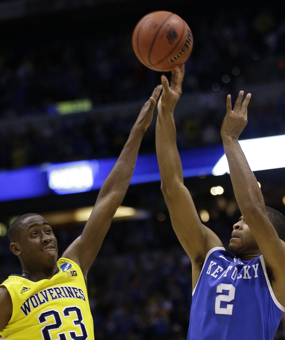 Kentucky's Aaron Harrison (2) shoots a three-point basket past Michigan's Caris LeVert (23) in the final second of the second half of an NCAA Midwest Regional final college basketball tournament game Sunday, March 30, 2014, in Indianapolis. (AP Photo/David J. Phillip)