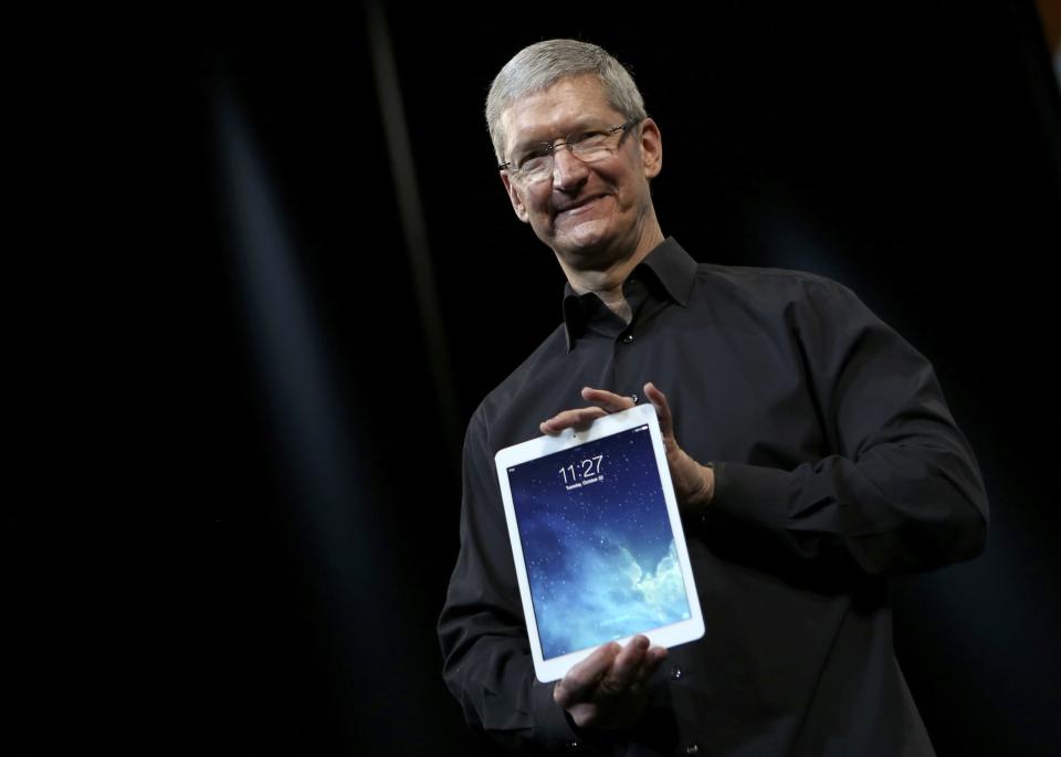 Apple Inc CEO Tim Cook holds up the new iPad Air during an Apple event in San Francisco, California October 22, 2013. REUTERS/Robert Galbraith (UNITED STATES - Tags: BUSINESS TELECOMS SCIENCE TECHNOLOGY TPX IMAGES OF THE DAY)