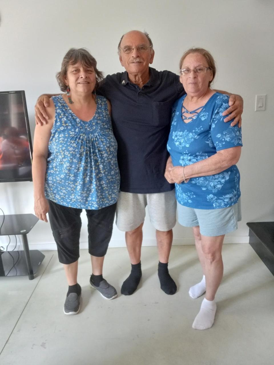 Ambrose is pictured with his sisters, Leona and Valerie. He says his biological parents' memories live on through them.