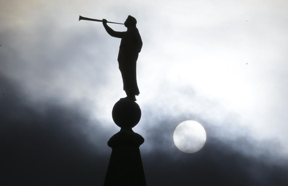 FILE - In this Jan. 29, 2013, file photo, the angel Moroni statue, silhouetted against a cloud-covered sky, sits atop the Salt Lake Temple in Temple Square in Salt Lake City. A newly-posted article, part of a series of recent online articles posted on the website of The Church of Jesus Christ of Latter-day Saints, affirms the faith's belief that humans can become like God in eternity, but explains that the "cartoonish image of people receiving their own planets" is not how the religion envisions it. (AP Photo/Rick Bowmer, File)