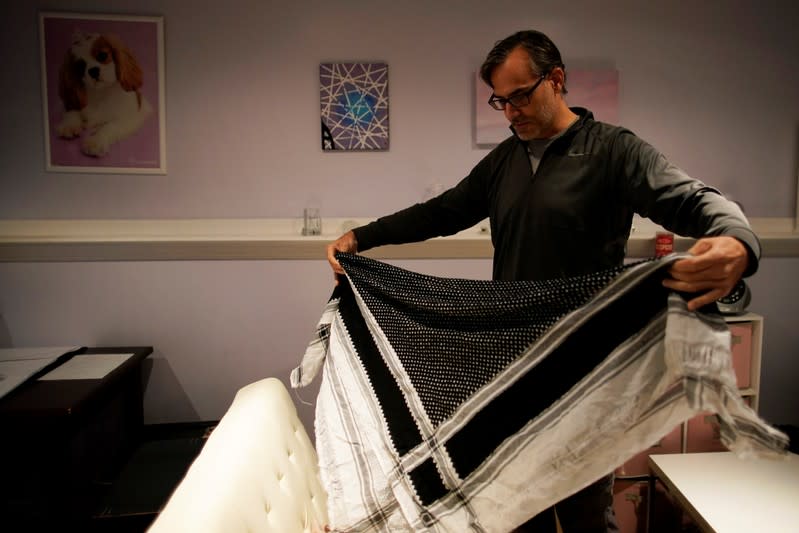 Mark Giaconia, who served for 20 years in the U.S. Army, of which 15 years in the U.S. Special Forces and was embedded with the Kurds in Iraq, folds his Kurdish scarf at his house in Herndon