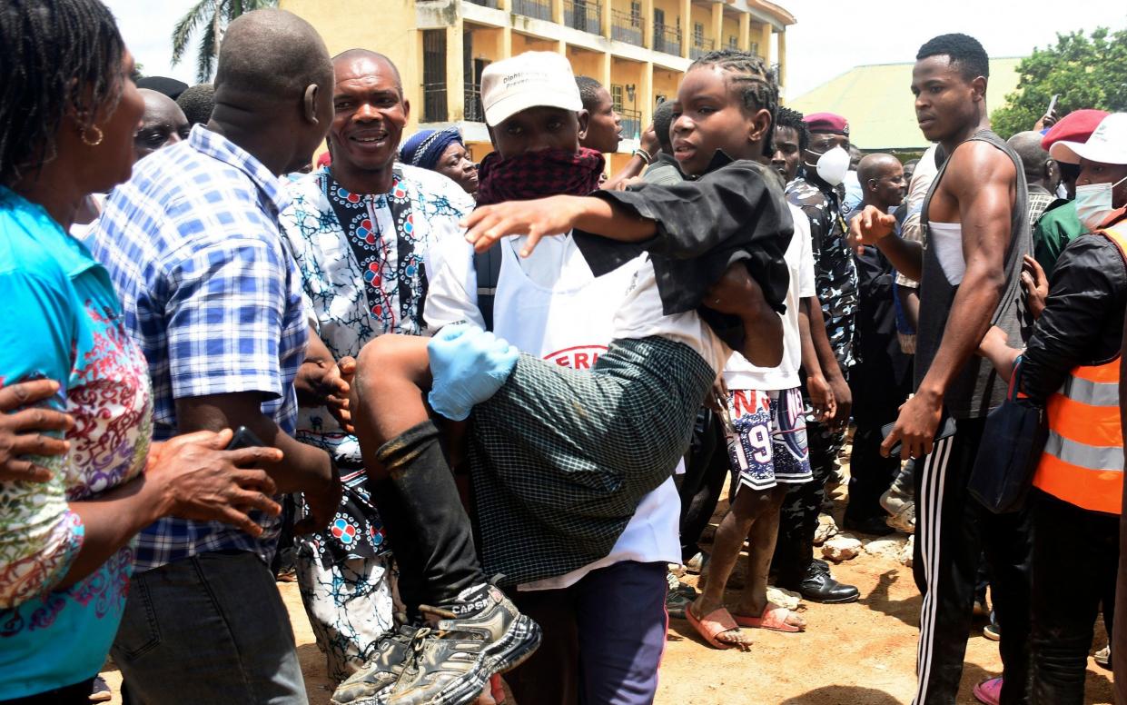 A young boy is carried to safety