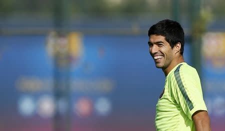 Barcelona's players Luis Suarez smiles during a training session at Joan Gamper training camp, near Barcelona October 20, 2014. REUTERS/Albert Gea