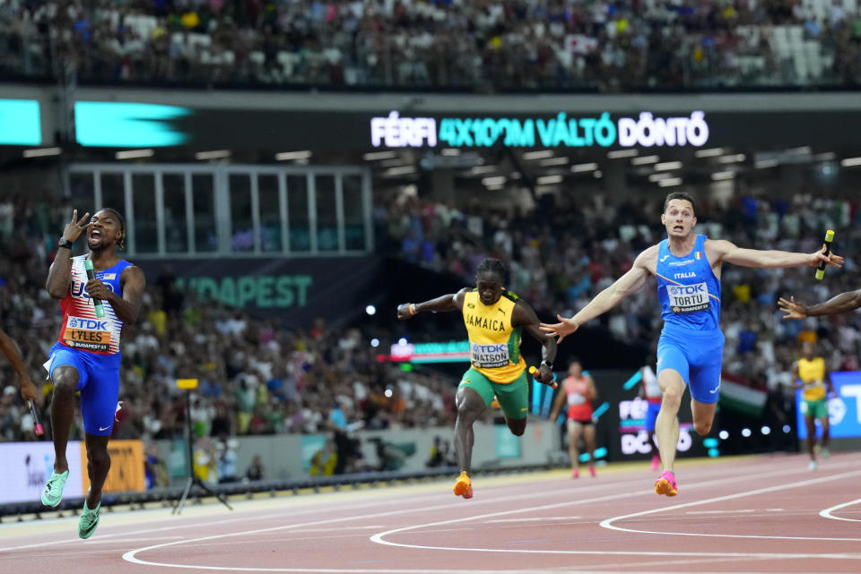 Noah Lyles, of the United States, left, celebrates anchoring his team to gold ahead of Filippo Tortu, of Italy in the Men's 4x100-meters relay final during the World Athletics Championships in Budapest, Hungary, Saturday, Aug. 26, 2023. (AP Photo/Petr David Josek)