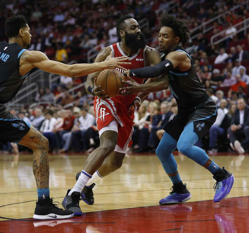 James Harden drives to the basket between Jeremy Lamb (L) and Devonte' Graham of the Hornets on Monday night. (Getty Images)