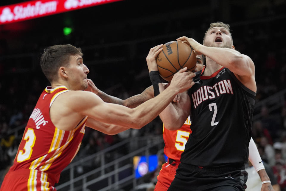 Houston Rockets center Jock Landale (2) is fouled by Atlanta Hawks guard Bogdan Bogdanovic (13) as he goes up for a basket during the first half of an NBA basketball game Saturday, Feb. 10, 2024, in Atlanta. (AP Photo/John Bazemore)