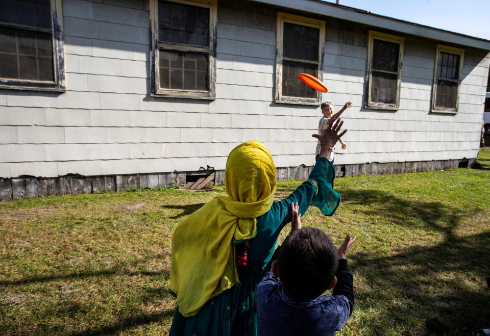 Volunteer Sandra Hoeser plays frisbee with Afghan refugees at Fort McCoy U.S. Army base, in Wisconsin, U.S., September 30, 2021. Barbara Davidson/Pool via / Credit: POOL / REUTERS