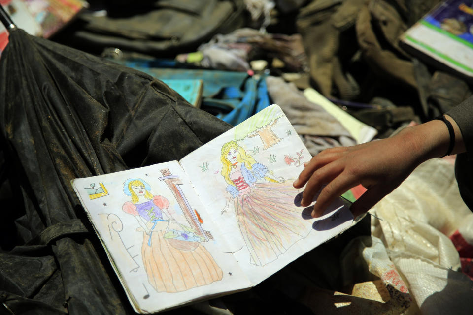 Afghans go through belongings left behind after deadly bombings on Saturday near a school, in Kabul, Afghanistan, Sunday, May 9, 2021. The Interior Ministry said the death toll in the horrific bombing at the entrance to a girls' school in the Afghan capital has soared to some 50 people, many of them pupils between 11 and 15 years old, and the number of wounded in Saturday's attack has also climbed to more than 100. (AP Photo/Mariam Zuhaib)