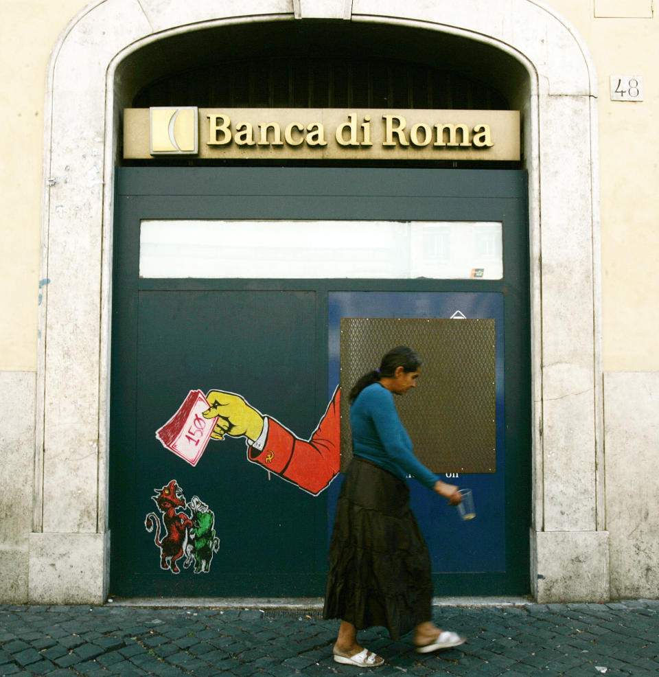 A woman who begs for money walks past a closed cash machine covered by a sticker in Rome, Tuesday, Aug. 14, 2012. Europe is edging closer to recession, dragged down by the crippling debt problems of the 17-country euro bloc, official figures showed Tuesday. Eurostat, the European Union's statistics agency, revealed that the economies of both the eurozone and the wider 27-country EU shrank by a quarterly rate of 0.2 percent in the second quarter of the year. In the first quarter, output for both regions was flat. A recession is officially defined as two straight quarters of falling output. (AP Photo/Gregorio Borgia)