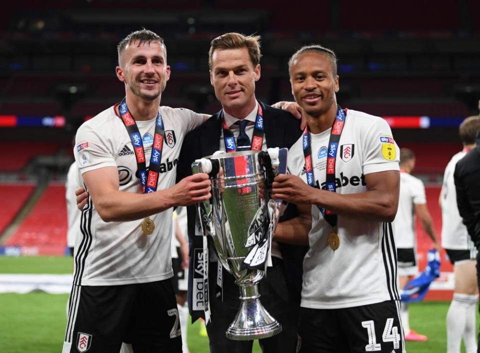 Joe Bryan (left) and Bobby Decordova-Reid hold the trophy with the Fulham manager, Scott Parker.