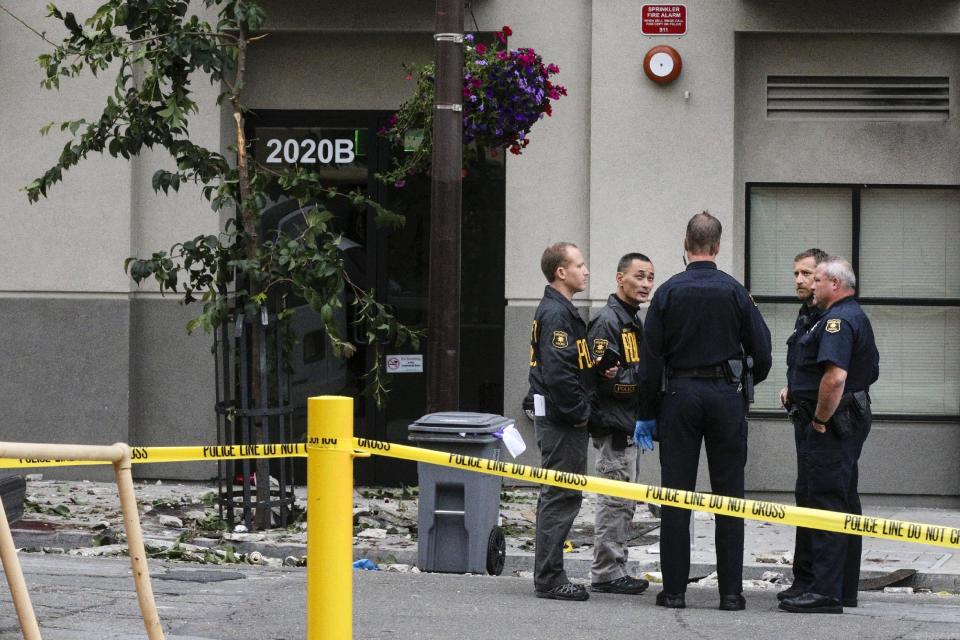 Berkeley Police officers confer at the scene of a 4th-story apartment building balcony collapse in Berkeley, California