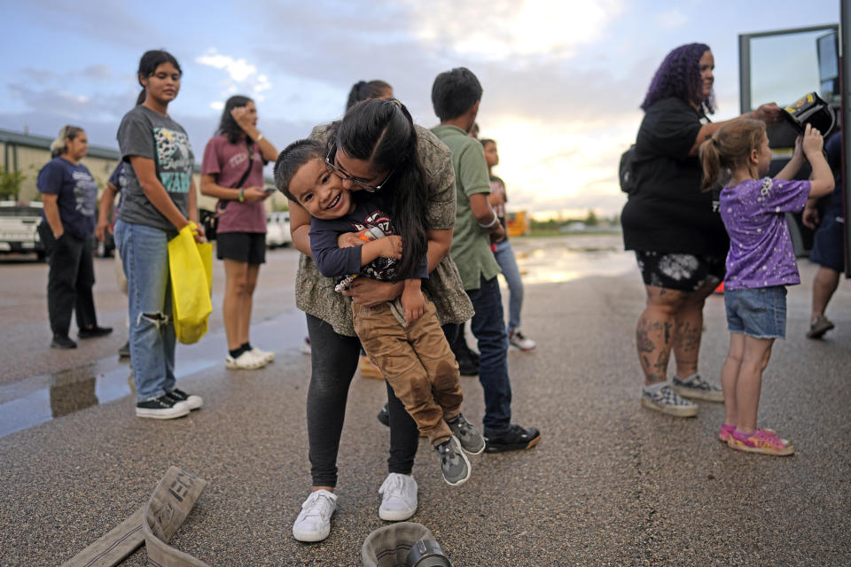 Gina Hernandez hugs her son Noah Hernandez, 3, while attending a National Night Out event in the Colony Ridge development Tuesday, Oct. 3, 2023, in Cleveland, Texas. The booming Texas neighborhood is fighting back after Republican leaders took up unsubstantiated claims that it has become a magnet for immigrants living in the U.S. illegally and that cartels control pockets of the neighborhood. (AP Photo/David J. Phillip)