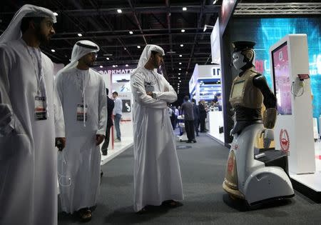 FILE PHOTO: Visitors look at an operational robot policeman at the opening of the 4th Gulf Information Security Expo and Conference (GISEC) in Dubai, United Arab Emirates, May 22, 2017. REUTERS/Stringer/File Photo