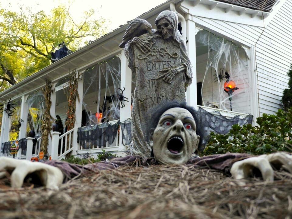 Fake zombie and gravestone Halloween decorations were placed outside a homeowners's residence.