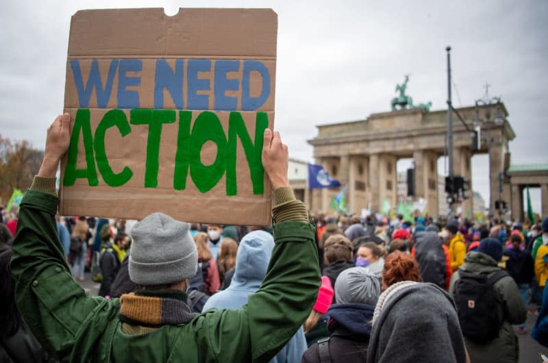 Someone holds up a poster at a Fridays for Future climate protest at Germany's Brandenburg Gate. Philipp Znidar/dpa