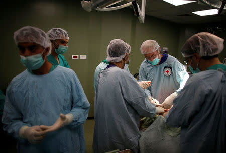 British vascular surgeon John Wolfe, who was invited to Gaza by the International Committee of the Red Cross (ICRC), performs a surgery for a wounded Palestinian in the operating room in a hospital in Gaza City April 25, 2018. REUTERS/Suhaib Salem