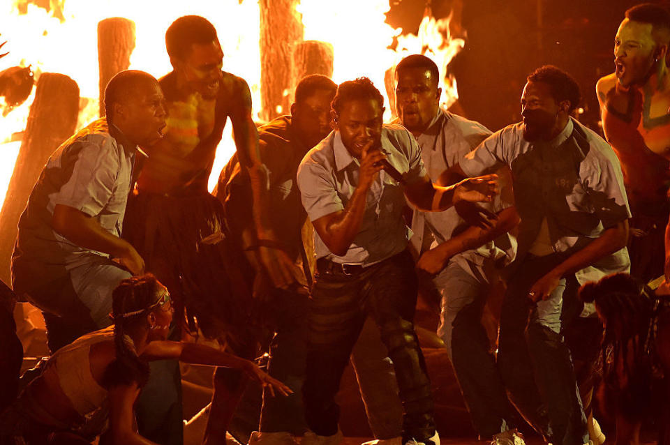 Kendrick Lamar and actors standing by fire