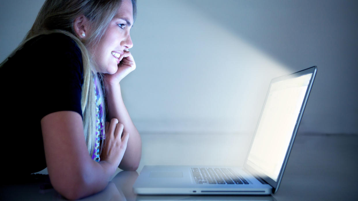  Woman grimacing at a bright computer screen. 