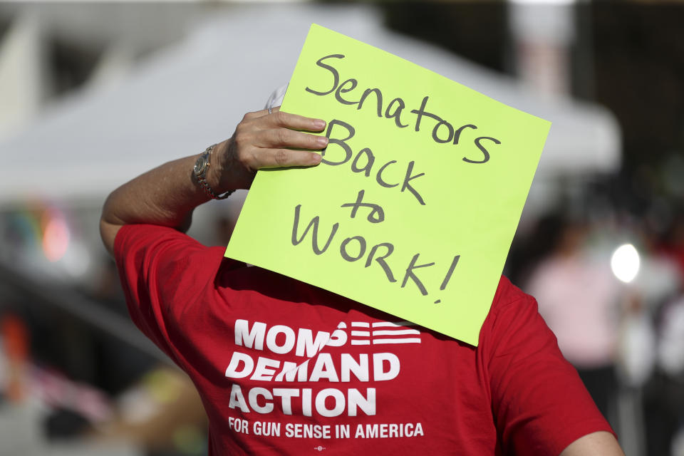 FILE - An attendee holds a sign behind their head during a rally calling for an end to the Senate Republican walkout at the Oregon State Capitol in Salem, Ore., May 11, 2023. Republicans and an independent senator in the Oregon Senate stretched a walkout Monday, May 15, to 10 days, triggering a new constitutional provision that prohibits lawmakers with 10 or more unexcused absences from being reelected. The walkout that began May 3 has stalled action on hundreds of bills, including on gun control, gender-affirming care and abortion rights, as a deadline threatened to disqualify them from being reelected. (AP Photo/Amanda Loman, File)