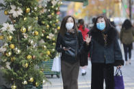 People wearing face masks to help curb the spread of the coronavirus walk at Ginza shopping district in Tokyo, Tuesday, Dec. 22, 2020. (AP Photo/Koji Sasahara)