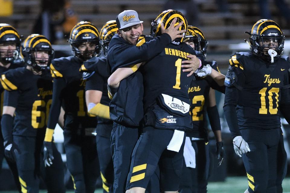 Snyder coach Wes Wood hugs Tim Henderson (1) after the Region I-4A Division II area playoff against Graham on Nov. 18 at Abilene's Shotwell Stadium. The Tigers won 14-3.