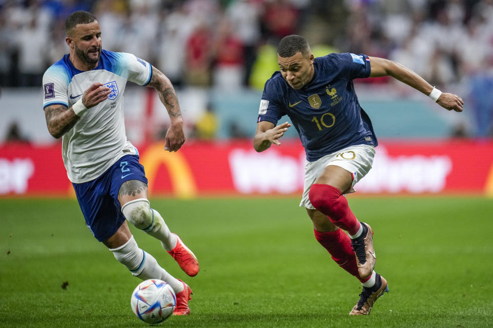 France's Kylian Mbappe, right, vies for the ball with England's Kyle Walker during the World Cup quarterfinal soccer match between England and France, at the Al Bayt Stadium in Al Khor, Qatar, Saturday, Dec. 10, 2022. (AP Photo/Christophe Ena)