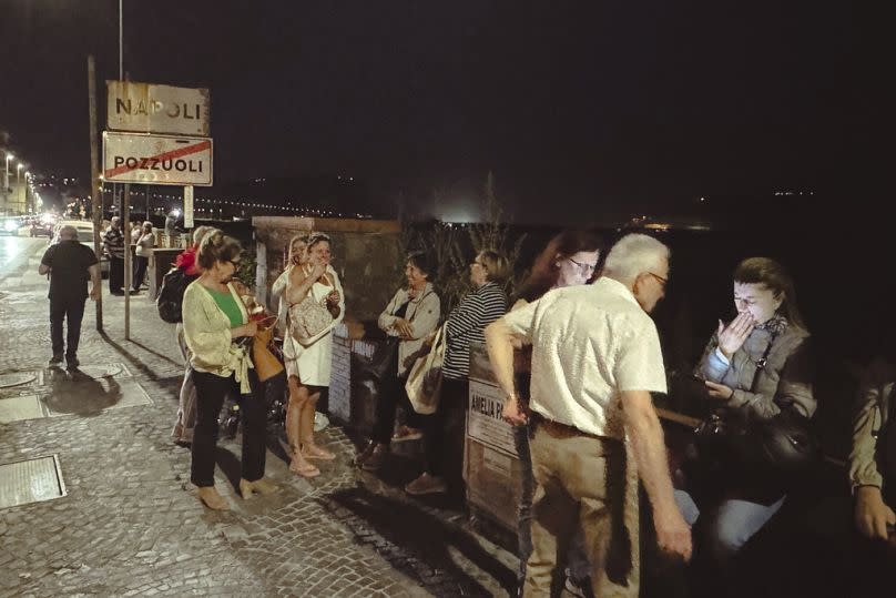 People gather in a street after an earthquake in Campi Flegrei, near Naples, Italy, Monday, May 20, 2024.