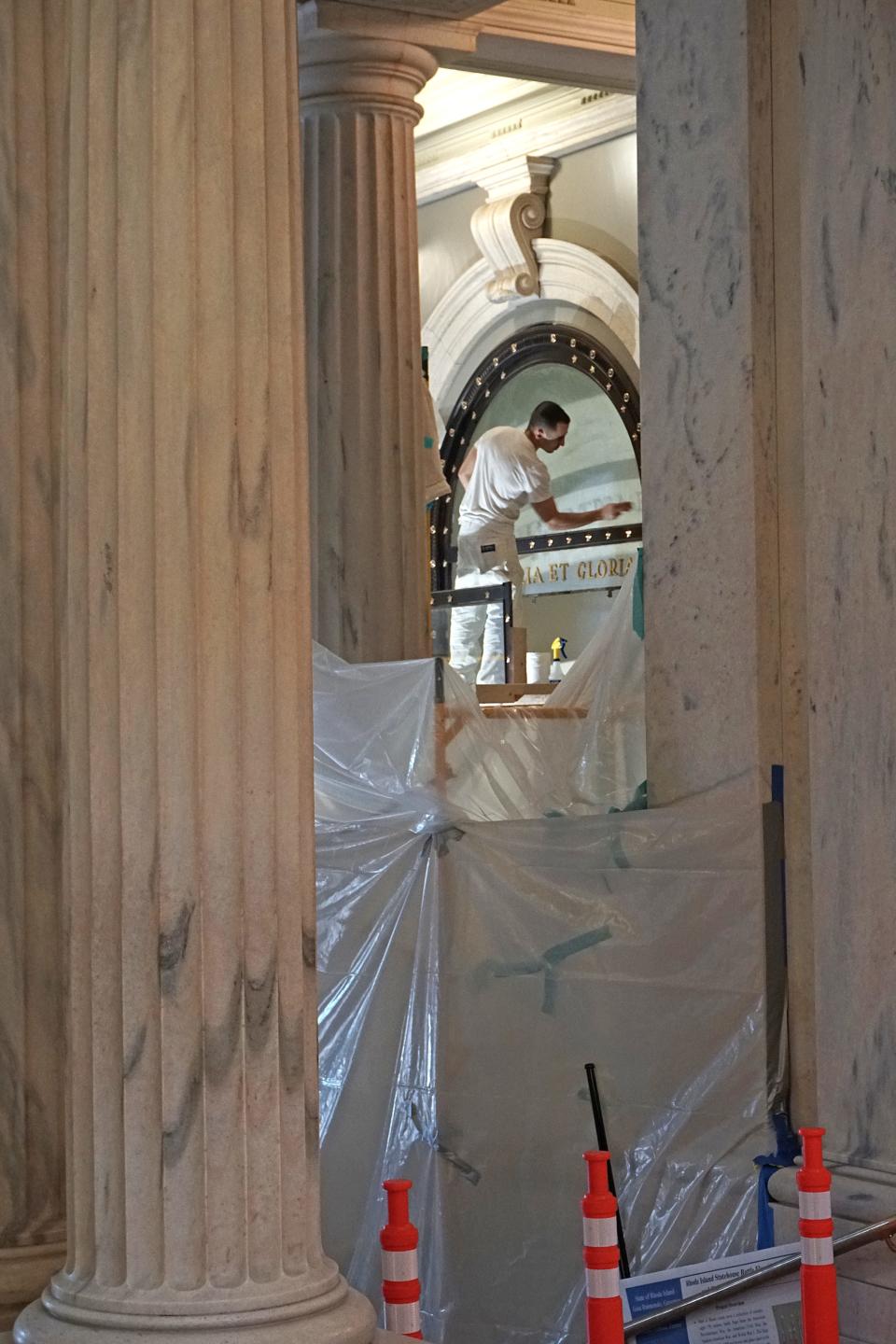 Juan Montoya, employed by E.F. O'Donnell & Sons in Providence, works on a scaffold restoring cases for the State House battle flags display in 2017.  [Sandor Bodo/The Providence Journal, file]