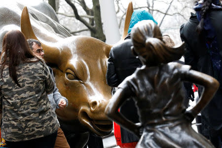 A statue of a girl facing the Wall St. Bull is seen, as part of a campaign by U.S. fund manager State Street to push companies to put women on their boards, in the financial district in New York, U.S., March 7, 2017. REUTERS/Brendan McDermid