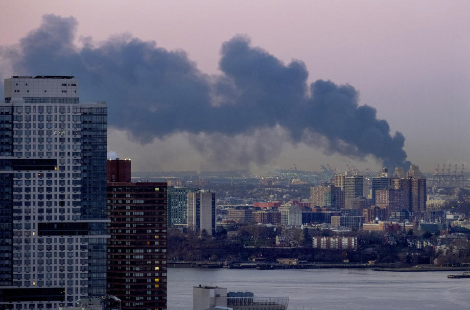 Smoke rises south of the New York borough of Manhattan as a warehouse burns in Elizabeth, N.J., spreading smoke over the southern skyline of New York Friday, Jan. 5, 2024. (AP Photo/Craig Ruttle)