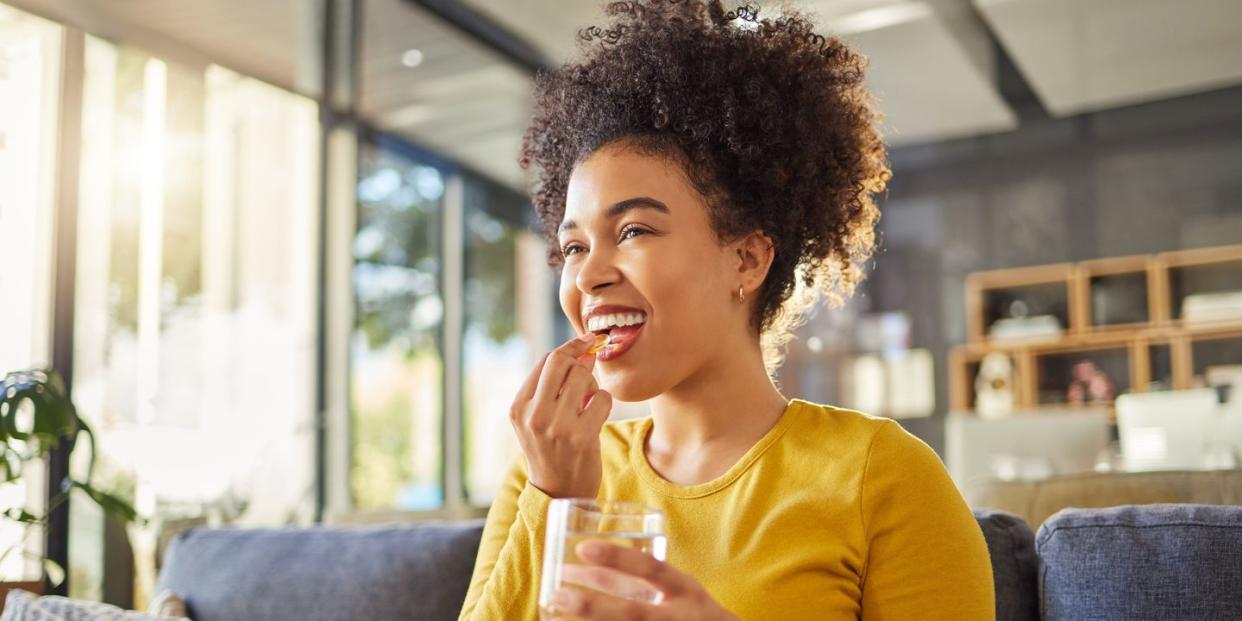 woman smiling taking a supplement