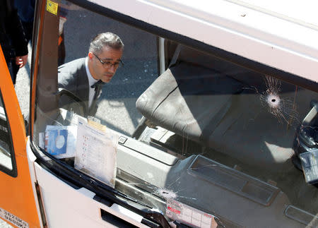 An investigator is seen inside a gas cylinder delivery truck with bullet holes in its windscreen after police fired shots to stop the driver, whom they say had stolen the truck and was driving against traffic, in Barcelona, Spain, February 21, 2017. REUTERS/Albert Gea