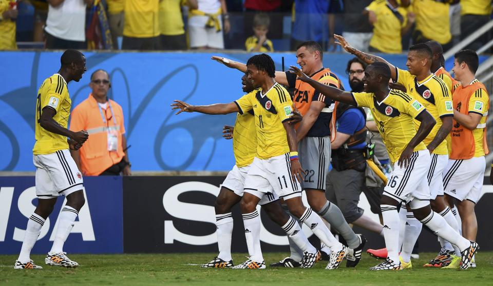 Colombia's team celebrates Juan Cuadrado's (C) goal during their 2014 World Cup Group C soccer match against Japan at the Pantanal arena in Cuiaba June 24, 2014. REUTERS/Dylan Martinez (BRAZIL - Tags: TPX IMAGES OF THE DAY SOCCER SPORT WORLD CUP)