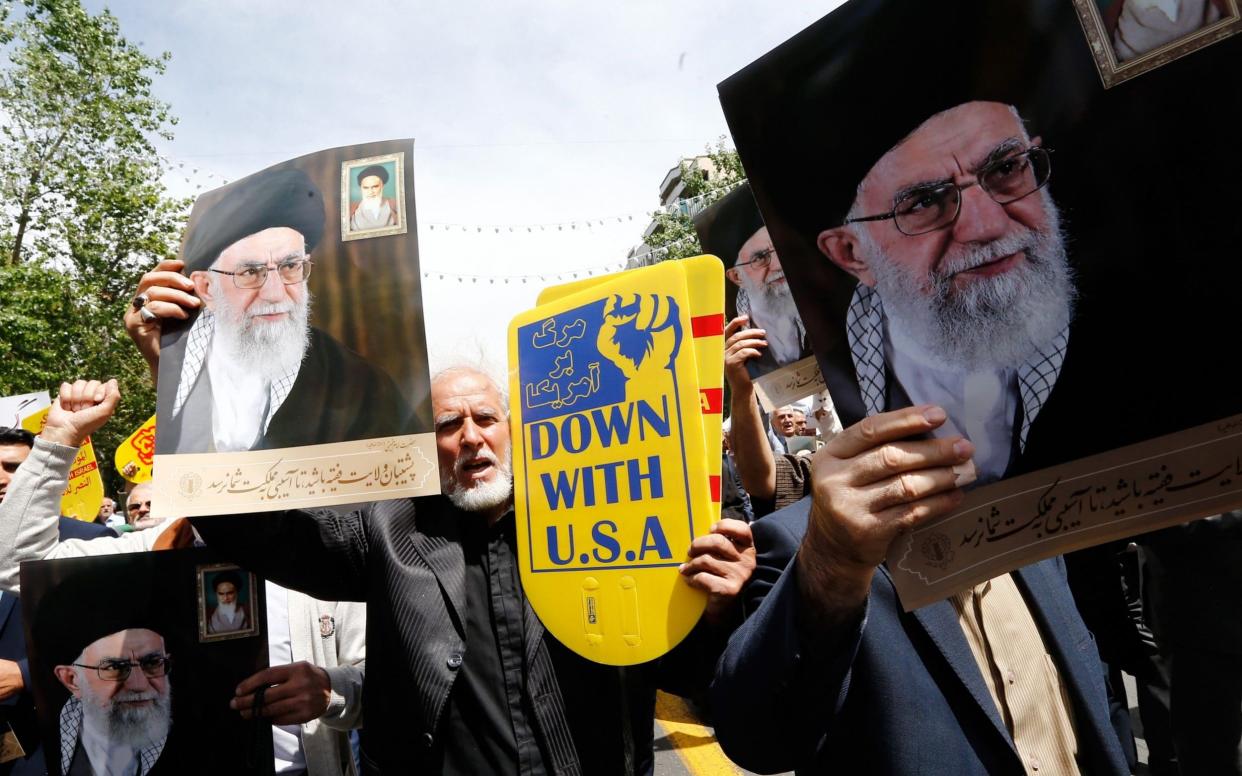 The president's announcement followed a public dressing down by Iran's supreme leader, Ayatollah Ali Khamenei, pictured in posters, over his handling of the nuclear deal - REX