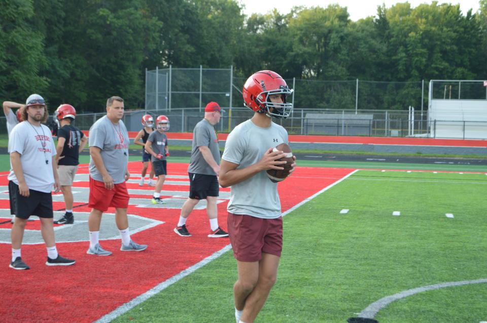 Former Morenci football coach, Stefan Wilkinson (back middle), watches on during a drill at Temperance Bedford.