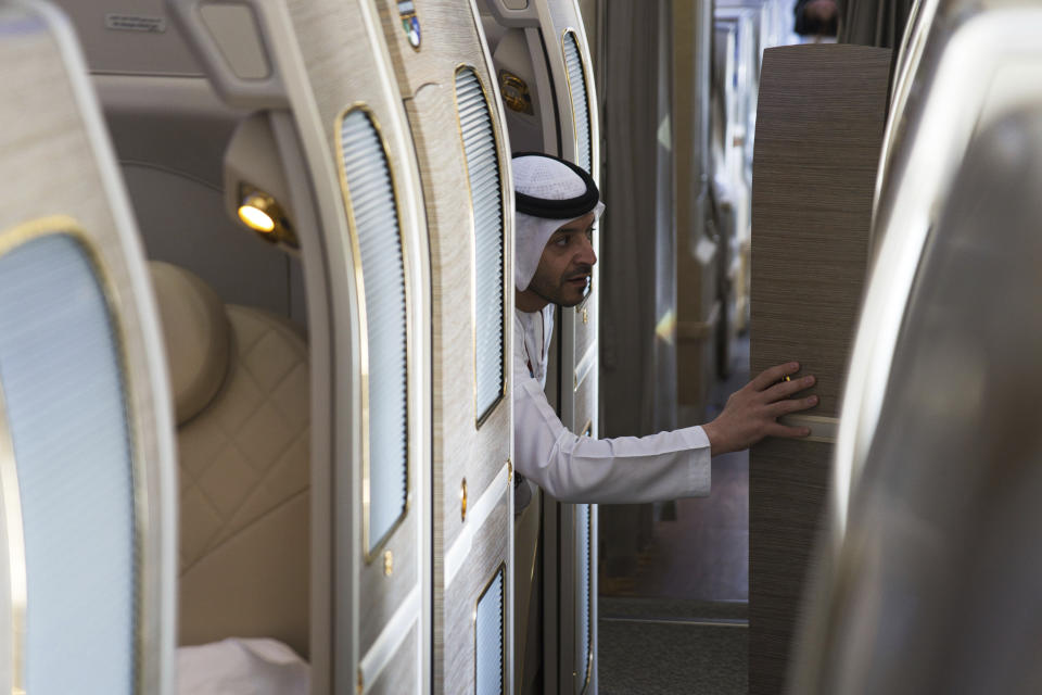 An Emirati reaches out to explore an Emirates Airbus A380 at the Dubai Air Show in Dubai, United Arab Emirates, Monday, Nov. 13, 2023. Long-haul carrier Emirates opened the Dubai Air Show with a $52 billion purchase of Boeing Co. aircraft, showing how aviation has bounced back after the groundings of the coronavirus pandemic, even as Israel's war with Hamas clouds regional security. (AP Photo/Jon Gambrell)