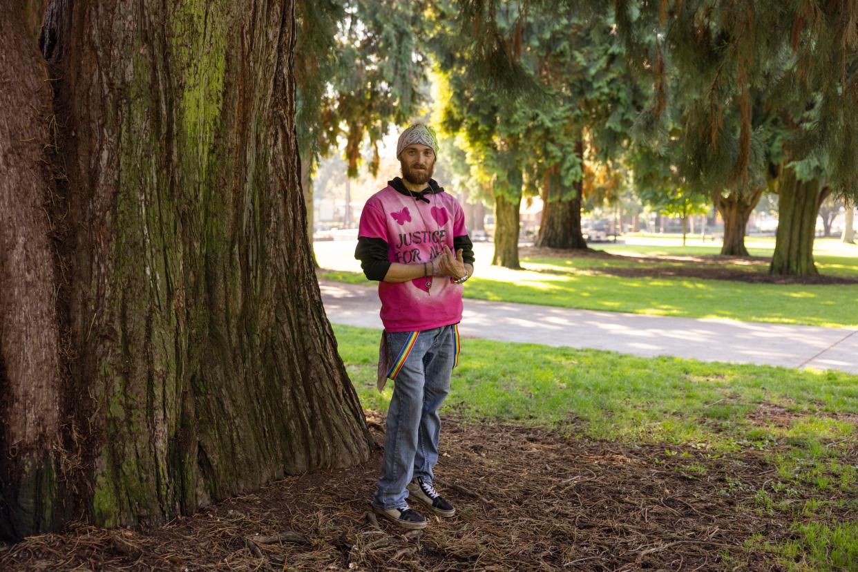 A man in a "justice for Nikki" shirt standing in front of a tree