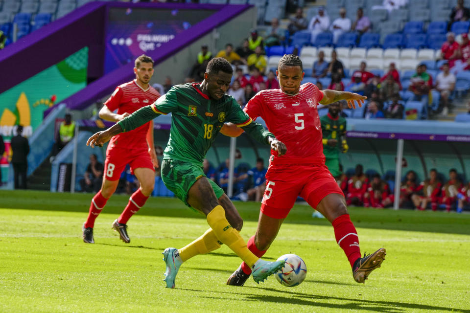 Cameroon's Martin Hongla, left, kicks the ball past Switzerland's Manuel Akanji during the World Cup group G soccer match between Switzerland and Cameroon, at the Al Janoub Stadium in Al Wakrah, Qatar, Thursday, Nov. 24, 2022. (AP Photo/Ricardo Mazalan)