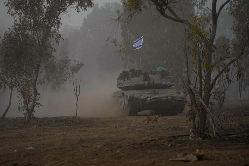 Israeli army tanks move along the Gaza Strip border, in southern Israel, Monday, Dec. 11, 2023. The army is battling Palestinian militants across Gaza in the war ignited by Hamas' Oct. 7 attack into Israel. (AP Photo/Ohad Zwigenberg)