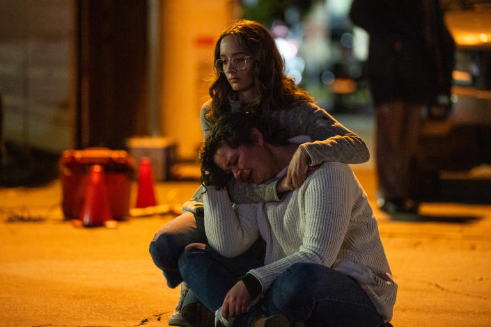 A woman holds another woman who is crying.