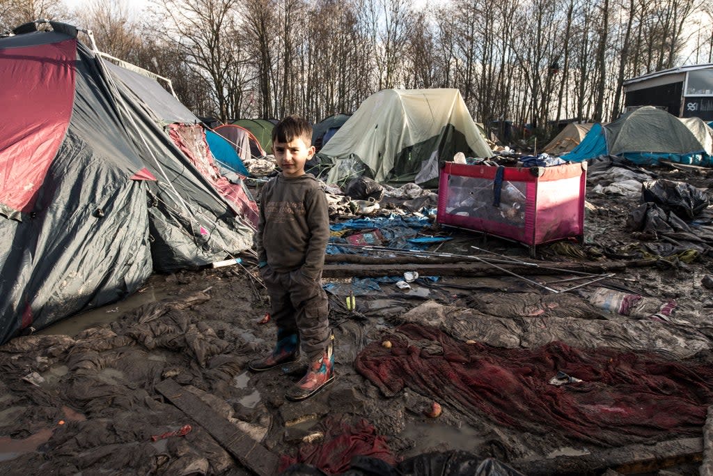 A boy poses in a migrant and refugee camp in Grande-Synthe near Dunkirk, northern France (AFP via Getty Images)