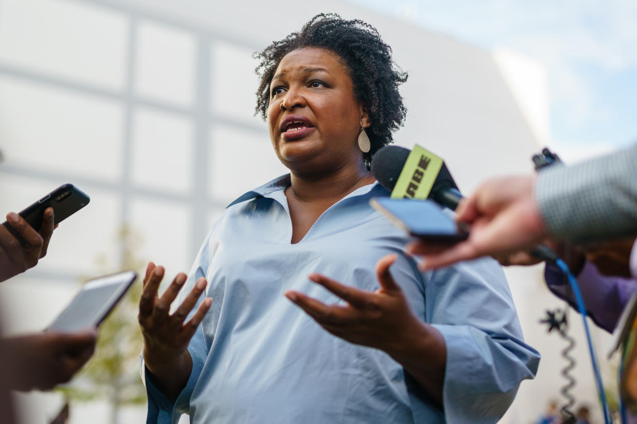 Stacey Abrams, surrounded by reporters, makes an emphatic point.